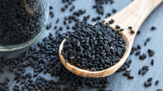 Black cumin seeds on a wooden spoon